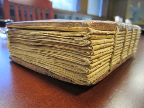 This image represents the most important features of Coptic book binding: link stitching and bare wooden boards. We can see folded quires with holes from stitching, the head of the codex and the spine (totally unprotected). Surprisingly, this book is a relatively modern one: it;'s a 19th century Ethiopian prayer book, hand-written on vellum.  Copyright: Gleeson Library Coptic Book Binding, Production Aesthetic, Book Binding Types, Book Binding Methods, History Of Paper, Types Of Binding, Binding Machines, Different Types Of Books, Coptic Binding