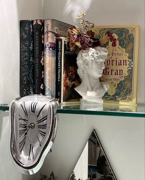 Bookshelf Hanging Wall, Book Holder Aesthetic, Bookshelf Decorative Objects, Book Decor Bedroom, Books On Desk Aesthetic, Melting Clock Decor, Book Display Ideas Bedroom, Bookshelf Inspo Bedroom, Weird Room Decor