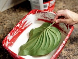 Dip each large leaf fully into the wet plaster. Gently shake off excess and clip the leaves onto a hanger with the points facing down. Pull the sides slightly together to create a bit of a fold in the leaf and allow leaves to dry. Prevent remaining wet plaster from drying out by covering with plastic wrap. How To Make Plaster, Wheat Bundle, Paris Crafts, Paris Flowers, Diy Plaster, Plaster Crafts, Cement Art, Plaster Of Paris, Concrete Crafts