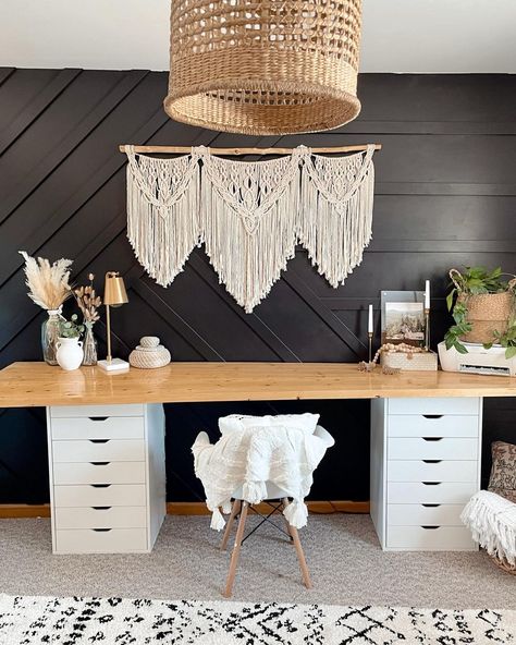 Simple boho touches create stunning ideas for office desk decor. Dried flowers, woven baskets, and wooden beads adorn the wooden counter on dual white storage units. A macrame wall hanging complements the boho theme. Boho Desk Aesthetic, White And Wood Desk, Boho Theme Office, Boho Western Office, Modern Boho Office, Boho Desk, Boho Home Office, Boho Office Room, Modern Desk Decor