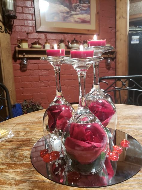 I took 3 different sized wine glasses, turned upside down, on a round mirror,  put a red rose inside, scattered heart charms around, and put heart shaped tea lights on top of the wine glass bottoms. Center Piece For Dining Table, Wine Glass Centerpieces, Wine Glass Decor, Red And White Weddings, Diy Wine Glasses, Wine Dinner, Dekor Diy, Hearts And Roses, Adult Crafts