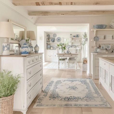 Created with Ai At the center of this kitchen lies a white and blue vintage rug, its intricate patterns drawing the eye and grounding the space. Surrounding it, white cabinets, their clean lines against the warmth of a wooden floor and delicate light wood ceiling beams. This kitchen is a celebration of summer, with plants that infuse the air with freshness and vitality. Atop the shelves, blue porcelain vases add a touch of sophistication, a dining table awaits, bathed in the soft glow of n... French Country Kitchens Blue, Blue And White Vintage Kitchen, Blue And White China Kitchen, Light Wood Ceiling, Wood Ceiling Beams, Blue Cottagecore, Blue Vintage Rug, Patterns Drawing, Cottagecore Kitchen