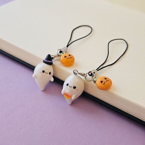 A cute ghost Phone Strap, perfect for Halloween. Choose your favourite style: with a Witch hat or holding a candy corn. 👻 Ghost charm is approx. 2.5 cm in height (1 inch).  👻 It comes with a tiny Jack-o-lantern charm. 👻 All my pieces are handmade so they might be slightly different from the one pictured. Halloween Clay Charms, Halloween Keychains, Clay Ghost, Clay Models, Halloween Keychain, Small Crafts, Halloween Clay, Halloween Bracelet, Boo Basket