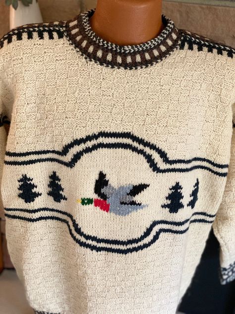 Attention all birders and waterfowl hunters! Whether you're out with your binoculars trying to capture the sight of another bird on your list or waiting for hours in the blind with only your Labrador Retriever to keep you company, the 'Duck' pattern hand knitted sweater is going to keep you warm! This gorgeous pullover has a duck as its central motif, framed by trees on the sides and double black yarn knitted lines, with a small rectangular knitted pattern comprising the cream colored upper ches Vintage Patterned Sweater, Duck Sweater Crochet Pattern, Knitted Sweaters Pattern, Duck Sweater Knitting Pattern, Knit Jumper Pattern, Knitted Goose, Tree Knitting Pattern, Duck Cardigan, Colorwork Sweater