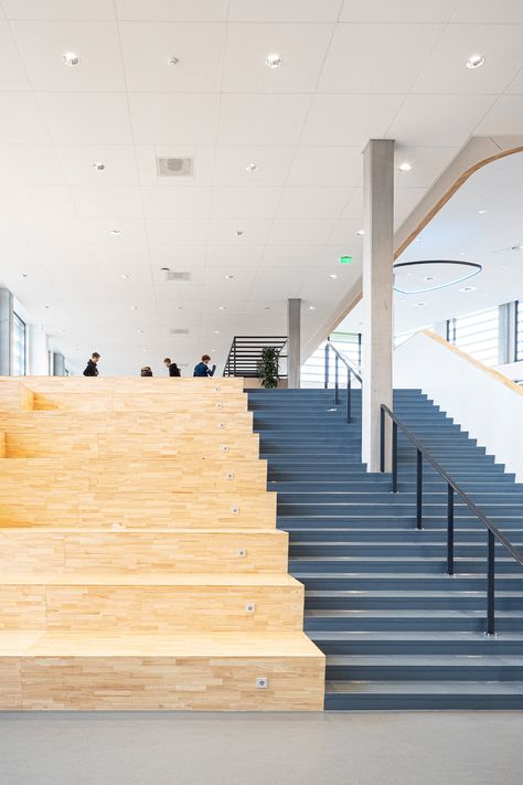 Modern educational institution in the Netherlands that has a light coloured wooden staircase and a white sleek ceiling that has LED lights scattered throughout. Acoustic Ceiling Tiles, Suspended Ceiling, Acoustic Solutions, Glass Roof, Ceiling Tiles, Wall Panels, Led Lights, This Is Us, Ceiling