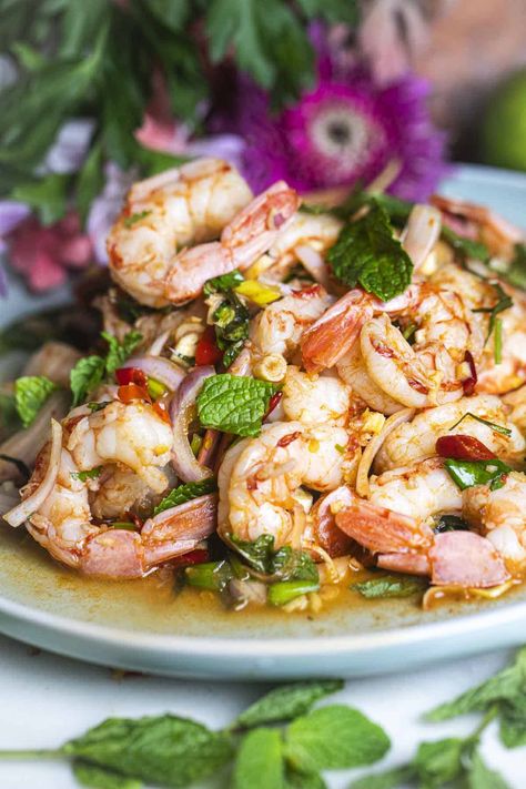 Need a tasty idea for a quick lunch? Try Pla Goong, a spicy Thai shrimp salad full of flavor. It has fresh herbs, big juicy shrimp, and spicy Thai chili peppers. The dressing is tangy and spicy too. Give your taste buds a treat with this yummy salad you'll want to eat again and again! #plagoongrecipe #plagoongingredients #plagoongsaladrecipe #thaishrimpsalad #spicythaishrimpsalad #prawnsaladthai #plagoongsalad Spicy Thai Shrimp, Spicy Shrimp Salad, Thai Shrimp Salad, Thai Chili Peppers, Thai Salad Recipes, Green Mango Salad, Thai Shrimp, Prawn Salad, Spicy Salad