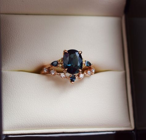 "Welcome our 2022 collection! Oval cut blue green teal sapphire engagement ring set by Eidelprecious. The ring is a twist on our bestseling Campari design. It features a 2.5 oval sapphire, amazing teal blue green color. Displays some color change. Very unique and rare one of a ring Our newest 2022 version of Campari setting features 4 round yellow diamonds and 2 pear teal sapphires. 14k Rose gold. Complimentary wedding band was designed specifically for this collection. Made in 14k rose gold, it