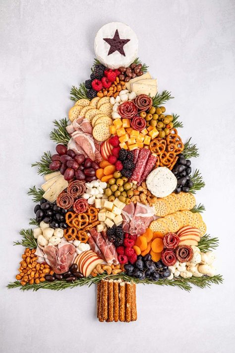 Charcuterie boards have taken the spotlight recently, and with the festive season approaching, why not create a charming Christmas tree charcuterie board for your holiday gathering? This playful and festive board can be crafted to any size you want. Picture an assortment of deliciously sliced meats and cheeses, paired with creamy cheeses, olives, crunchy pretzel sticks, and a colorful mix of fresh fruits and veggies. And you can feel free to add any other treats that tickle your festive fancy! Cheese Platter Ideas For Christmas, Christmas Antipasto Platter Ideas, Yule Charcuterie Board, Xmas Platter Ideas, Christmas Inspired Charcuterie Board, Holiday Cookie Charcuterie Board, Christmas Charcutiere Board, Holiday Party Boards, Veggie Board Christmas