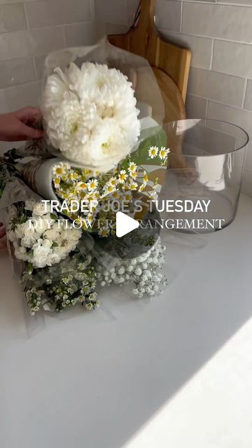 Amanda Hernandez on Instagram: "Large DIY flower arrangement for $28 💐  Trader Joe’s is my go to for flower arrangements. The prices are great and if you go early in the morning the selection is usually top notch!   For this arrangement I went with all white and greenery to give a very country feel. I made this for my 1980’s country goose themed ladies luncheon - so make sure you come back to see this arrangement used on my tablescape 🪿✨  #traderjoes #traderjoesflowers #flowerarrangement #diyflowers #tablescape #springvibes #explore" Shallow Dish Flower Arrangement, How To Build A Flower Arrangement, Engagement Party Floral Arrangements, Trader Joes Flower Arrangements Diy, Trader Joe’s Diy Flowers, Trader Joe Flower Arrangement, Trader Joes Bouquet Diy, Flower Arrangements Trader Joe’s, How To Make Flower Arrangements