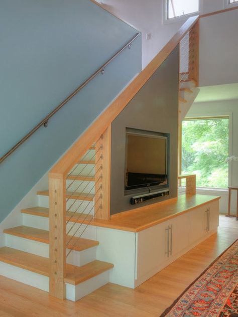 I like how this uses solid wall to support the TV and a more open railing everywhere else. Under Staircase Ideas, Living Room Under Stairs, Staircase In Living Room, Room Under Stairs, تحت الدرج, Step Shelves, Modern Traditional Home, Stairs Design Interior, Stairs In Living Room