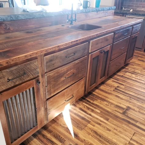 Kitchen of your dreams? Ours too! Check out the live edge concrete, corrugated tin in the doors, and open shelving under the cabinets. This is a show stopper. Custom build just for this space. Come design your dream kitchen with us! 
#Reclaim Renew #customkitchen #kitchen #eat #custom #custombuild #corrugatedtin #barnwood #rustic #farmhouse #style Rustic Cabin Kitchens Open Shelves, Farmhouse Kitchen Open Cabinets, Kitchen Cabinet Rustic Farmhouse Style, Rustic Cabinets Farmhouse Style, Under Counter Cabinet Ideas, Corrugated Tin Cabinets, Open Cabinets In Kitchen Farmhouse Style, Glazed Kitchen Cabinets Farmhouse, Rustic Tin Cabinets