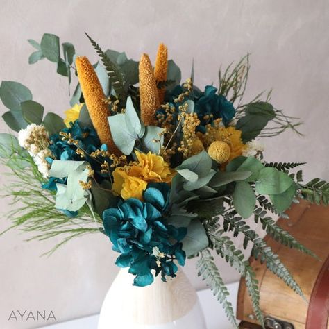 A bold bouquet with an assertive style in natural flowers to boost your decor. It will also be a very original gift to offer. Refined and ultra trendy bouquet in duck blue and mustard yellow: a contemporary and coherent duo that will bring cheerfulness and freshness to any room. This bright bouquet is made of real flowers and natural foliage: preserved hydrangea and foliage. Dried statice, craspedia, broom and babala.These natural dried or preserved flowers will allow you to fully enjoy this pre Teal Centerpieces, Preserved Flowers Bouquet, Yellow Flower Arrangements, Mustard Wedding, Preserved Hydrangea, Tropical Wedding Theme, Eucalyptus Bouquet, Dried Flower Wreaths, Dried Flower Bouquet