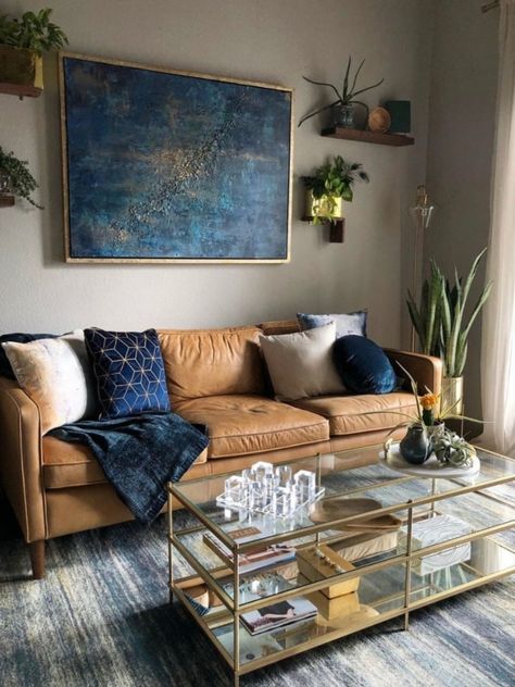 FALLing hard with all these Fall tones.⁠ ⁠Styles by @westelm ⁠#twelveriversrealty #livingroom #westelm #houseplants #blue #gold⁠ Brown Leather Couch Living Room Decor Navy Blue, Navy Blue And Cognac Living Room, Brown And Navy Living Room, Tan And Blue Living Room, Navy And Brown Living Room, Tan Couch Living Room Ideas, Blue And Tan Living Room, Blue And Brown Living Room, Brown Leather Couch Living Room