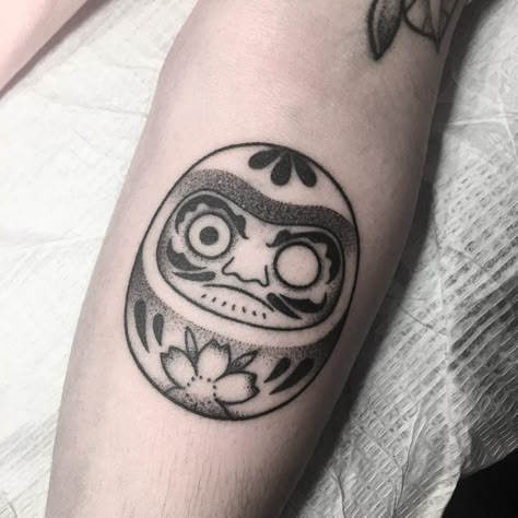 • "A Daruma Doll is a hollow, round, Japanese traditional doll modeled after Bodhidharma, the founder of the Zen tradition of Buddhism. • Though considered a toy by some, Daruma has a design that is rich in symbolism and is regarded more as a talisman of good luck to the Japanese. • When purchased, the figure's eyes are both blank white. A user will then select a goal or wish and paint in one of the figure's two eyes. Once the desired goal is achieved, the second eye is filled in." • Merci Simon Paper Tattoo Design, Tattoo Designs On Paper, Taurus Tattoo Design, Daruma Tattoo, Daruma Doll Tattoo, Traditional Japanese Tattoo Flash, Lucky Cat Tattoo, Paper Tattoo, Tato Tradisional