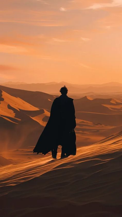 The image shows a lonely figure standing on a sand dune in the middle of a vast desert. The figure is wearing a long black cloak and is facing away from the viewer ->> more details in ai-img-gen.com Desert Robes, Black Sand Desert, Julian Aesthetic, Scifi Ideas, Apocalypse Landscape, Giant Skeleton, Book Couples, Black Cloak, Silhouette People