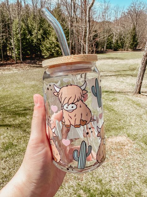 This highland cow glass tumbler is perfect for iced coffee or your favorite cold drink. High quality permanent uv is used for this design on the 16 oz glass beer can style cup. You can order the glass by itself, or you can add on the bamboo lid and a reusable glass straw. To order: 1. Select Item Options: -Glass only -Glass w/ Lid & Straw 2. Select quantity! All glasses and bamboo lids are HAND WASH ONLY! If you have any questions or customization ideas, please message me! Due to the customizati Highland Cow Glass Cup, Cute Ice Coffee Cups, Cute Aesthetic Water Bottles, Cute Glass Bottles, Bamboo Glass Design, Cute Cup Designs Ideas, Can Cup Design, Tumbler Cup Design Ideas, Coffee Glass Cup Design