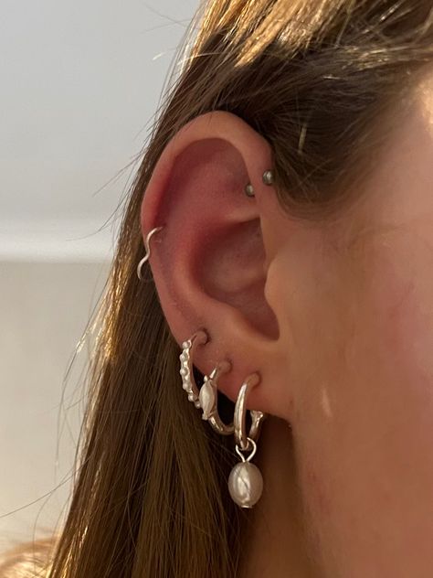 Silver earrings set, pearls, forward helix and heart hoop helix Silver Earring Styling, Eat Piercings Silver, Triple Lobe Piercing Hoops Silver, Earring Combos Silver, Lots Of Ear Piercings Silver, Silver Ear Jewelry Aesthetic, Silver Earrings Layered, Silver Earrings Set Up, Piercings Silver Ear