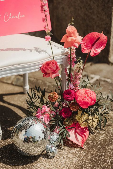 Hot pink theme wedding at Polstrong Manor with fun & vibrant retro decor. The bride wears a short wedding dress and a sparkly reception dress. Pink And Orange Disco Ball Wedding, Flower Arrangements With Disco Balls, Pink Boho Flower Arrangements, Disco Ball Flower Arrangements, Disco Ball And Flowers, Disco Ball Flowers, Flowers And Disco Balls, Sparkly Reception Dress, Disco Ball Wedding Decor