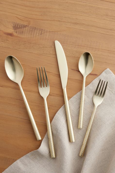 Finished with a light champagne-gold color and a modern hammered texture, our Champagne Satin Hammered Flatware Collection brings a luxe, contemporary look to the table. Perfect for entertaining and everyday dining, this silverware completes your place settings with a warm, alluring glow. #WorldMarket #Flatware #Silverware #Dining #Dinnerware Hammered Flatware, Silverware Sets, Gold Silverware, Champagne Gold Color, Gold Flatware, Dinner Fork, Stainless Steel Flatware, Contemporary Dining, Colorful Table