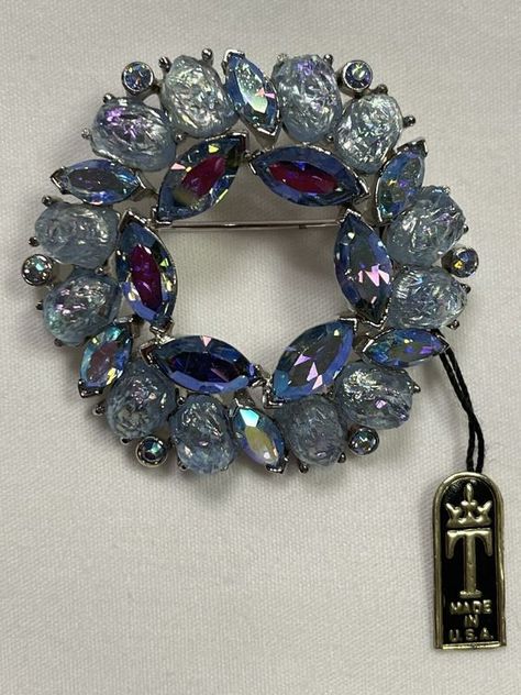 Vintage 1950-1960 New with original tag TRIFARI Etoile Blue Rhinestone Wreath Brooch, Blue Lava Nugget Stones and Blue Aurora Borealis Rhinestones! Designed by Alfred Philippe famous designer who worked for Cartier. This incredible brooch is crown Trifari signed and features oval shaped blue AB sheen lava stones, perfect little nuggets! There are also teensy blue aurora borealis chatons and vivid blue aurora borealis marquise rhinestones, all paste set in rhodium. This is such a fantastic piece, it's so easy to see why it's so collectible! Amazing looking super rare and in amazing condition. Very collectable. Rhinestone Wreath, Blue Lava, Circle Wreath, Blue Aurora, Vintage Jewelry Antique, Blue Aurora Borealis, Vintage Rhinestone Brooch, Jewelry Board, Trifari Jewelry