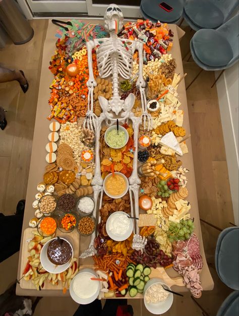 Halloween grazing table with life-size skeleton charcuterie Trader Joe’s Halloween Grazing Table, Halloween Charcuterie Board Ideas, Halloween Bunco, Pumpkin Shaped Cookies, Retro Living Room Decor, Life Size Skeleton, Halloween Charcuterie Board, Profitable Woodworking Projects, Halloween Charcuterie