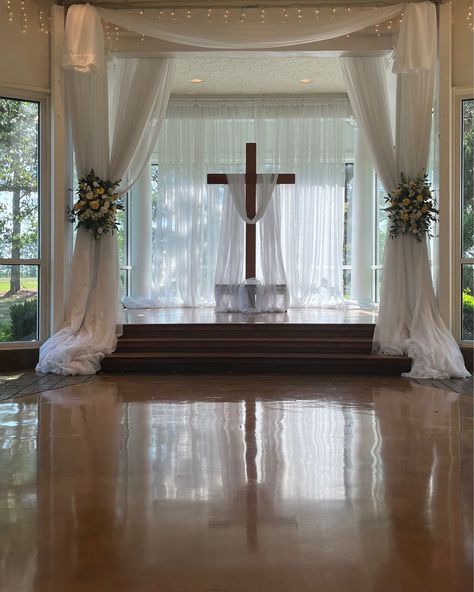 Getting ready for a ceremony at the altar with cross with drapery accent and beautiful flower tie backs. #houseestate #indoorceremony #houstonweddings Altar Wedding Indoor, Wedding Altar Indoor, Cross Backdrop Wedding, Cross Altar Wedding, Altar Flowers Wedding, Wedding Altar, Wedding Alters, Altar Flowers, Wedding Cross