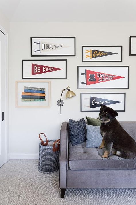 Framed sports banners hang in a charming boy's bedroom over a gray sofa placed on gray carpeting beside a gray woven basket. Boy's Rooms, Kids Sports Room, Sport Bedroom, Teen Boy Room, Big Kids Room, Black And White Pillows, Teen Boy Bedroom, Light Grey Rug, Sports Room