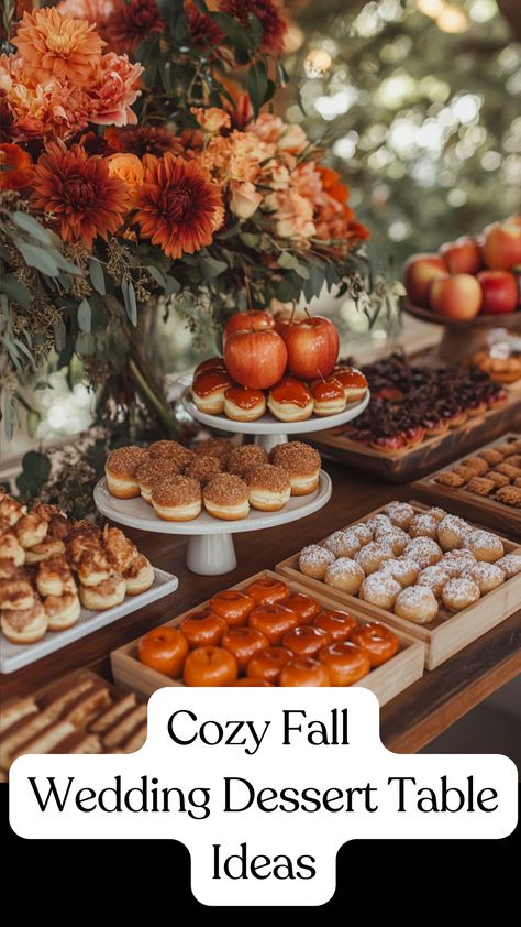 A cozy fall wedding dessert table featuring apple cider donuts, pumpkin pie bites, caramel-dipped apples, and spiced cookies displayed on rustic wooden trays with burlap accents and warm-toned flowers for a seasonal celebration. Wedding Table Treats, Fall Wedding Food Table, Thanksgiving Dessert Table Decoration, October Wedding Food, Fall Food Table Display, Non Cake Wedding Desserts, Fall Wedding Foods, Fall Baby Shower Dessert Table, Fall Baby Shower Desserts