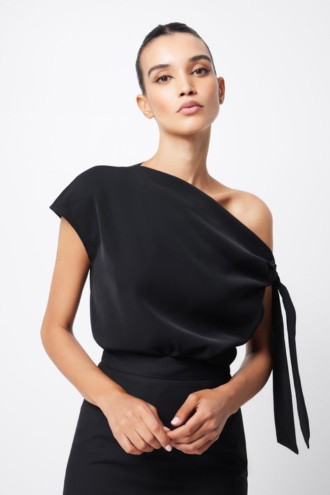 Imbued with a modern, minimalist appeal, The Drop Off Top is a sophisticated staple piece designed to take you from desk-to-dinner. In a classic shade of black, this design features an asymmetric neckline with a unique shoulder tie. This relaxed fit blouse delivers a fresh perspective for the modern woman. Features: Tie shoulder Off the shoulder Long-line