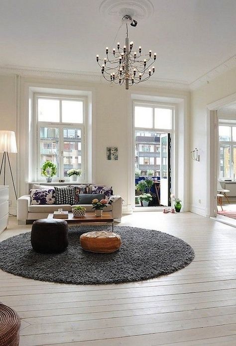 Although rectangular shaped rugs are the go-to shape when rug shopping, choosing a round rug could be the better choice for your room. Read on for tips! Scandinavian Apartment, Design Apartment, White Floors, Room Interior Design, Round Rug, A Living Room, Apartment Design, Home Fashion, Apartment Living