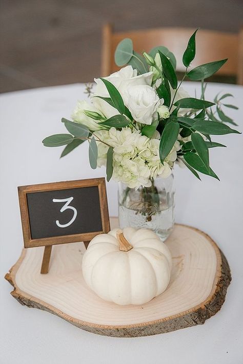 a neutral rustic centerpiece of a wood slice, a white pumpkin, white blooms in a jar and a chalkboard table number Diy Fall Wedding Centerpieces, Oyster Roast, Fall Wedding Tables, Pumpkin Wedding, Surprise Wedding, Wedding Boots, Fall Wedding Centerpieces, Rustic Fall Wedding, Wedding Floral Centerpieces