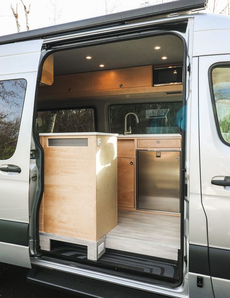 Sojourn - Freedom Vans Sprinter 144 Conversion, Corian Sink, Laminate Plank Flooring, Kitchen Galley, Converted Vans, Stainless Steel Microwave, Ottoman Cushion, Van Interior, Van Living