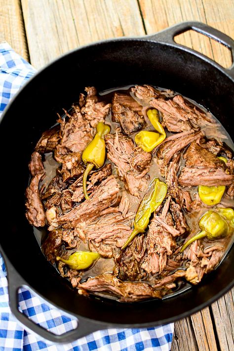 A chuck roast in a black dutch oven with peppers. Chuck Roast In Dutch Oven Recipe, Pot Roast Cast Iron Dutch Oven, Mississippi Pot Roast In Dutch Oven, Mississippi Pot Roast Dutch Oven, Dutch Oven Mississippi Pot Roast, Peppercini Roast, Pepperchini Roast, Chuck Roast In Dutch Oven, Oven Mississippi Pot Roast