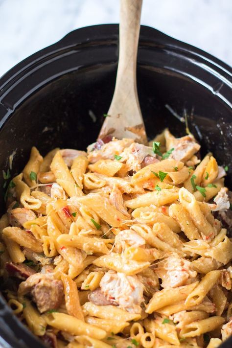 This Slow Cooker Cajun Chicken Alfredo is full of chicken, peppers, andouille sausage, and a creamy homemade alfredo sauce made right in your crockpot. | www.persnicketyplates.com Slow Cooker Cajun Chicken Alfredo, Slow Cooker Cajun, Sausage Alfredo Pasta, Cajun Chicken Pasta Recipe, Crockpot Chicken Alfredo, Cajun Chicken Pasta Recipes, Chicken Peppers, Slow Cooker Pasta Recipes, Cajun Chicken Alfredo