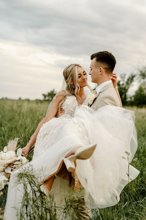 Nebraska based wedding photographer captures dreamy photos of a bride and groom in a field in Nebraska showing the bride in a beautiful white lace dress with floral details and a long veil and the groom in a tan suit while they walk through the field and he carries her.    #nebraskaweddingphotographer #brideandgroomportraits #romanticcoupleposes #coupleposingideas #weddingposes #weddingportraits Field Wedding Photography, Whimsical Wedding Pictures, Southern Wedding Photos, Short Bride Tall Groom Pictures, Wedding Picture Poses With Family, Bridal Portrait Ideas Outdoor, Groom Holding Bride, Groom Carrying Bride, Wedding Picture List