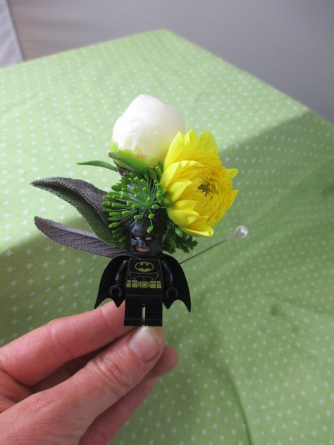 Batman for the groom! Mid June wedding. Lego boutonniere. All local flowers and greenery. Batman Boutonniere, Lightsaber Boutonniere, Batman Grooms Cake Wedding, Wedding Cake Batman, Batman Wedding Theme, Comic Book Wedding, Batman Decor, Batman Wedding, Lego Wedding