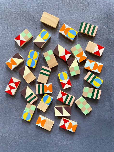 Vivid colors and bold graphics distinguish this modernist dominoes set designed by Panisa Khunprasert and made in Thailand of sustainably grown rubberwood. Lively fun for all ages. 28 dominoes in an 8 3/4 x 8 3/4 x 1 3/4 inches box Domino Design, Modular Art, Wooden Marble Run, Lamp Aesthetic, Wooden Toys Design, Domino Art, Domino Games, Dominoes Set, Project List