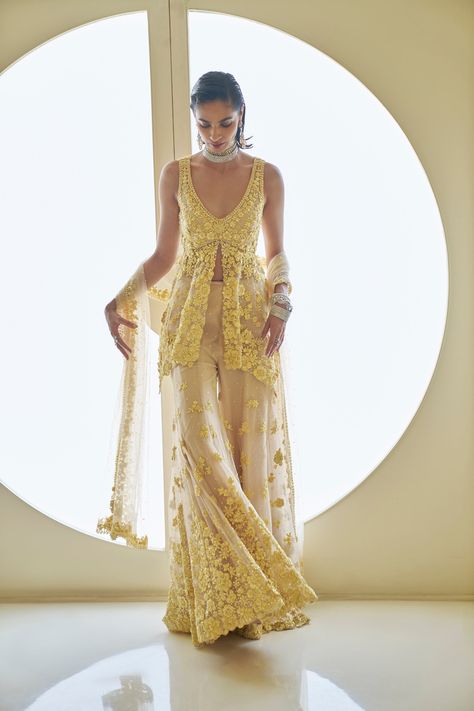 This sharara set features three-dimensional yellow floral embroidery on a nude tulle base. The peplum top is paired with a four-sided embroidered dupatta.From Seema Gujral's Fiori - the sharara edit collection. DELIVERY TIMEPlease allow 8-12 weeks for your outfit to arrive. FABRIC DETAILSNet Professional cleaning only. Haldi Dress For Bride Sister, Floral Sharara, Dress For Bride Sister, Haldi Dress For Bride, V Flower, Seema Gujral, Haldi Dress, Bride Sister, Embroidered Dupatta