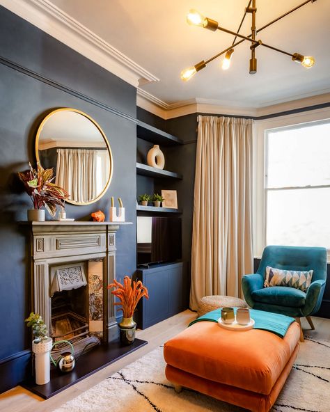 Who says dark walls can’t feel light? 🌌 This deep blue room gets a lift from natural light, bright accents, and a stunning brass lighting fixture. The balance between moody and vibrant makes this space feel dynamic yet cosy. 🎨 @farrowandball “Hague Blue” 📸 @lsouza_photography #DarkInteriors #BlueRoom #MoodyDesign #NaturalLight #FireplaceStyle #BoldAccents #InteriorStyling #CosyCorners #BrassLighting #HomeInspo #TealAndOrange Deep Blue Room, Blue And Orange Living Room, Navy Living Room, Navy Accent Walls, Navy Living, Fireplace Style, Navy Living Rooms, Home Music Rooms, Hague Blue