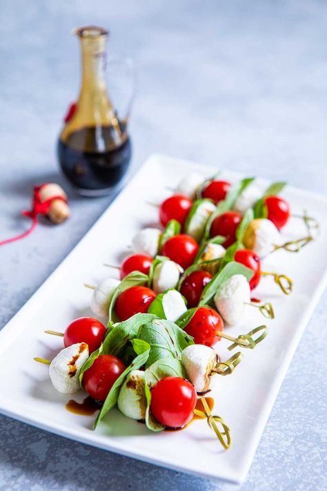 Caprese Skewers comprise cherry tomatoes, mozzarella pearls and basil leaves threaded onto cocktail sticks. Drizzle with balsamic vinegar. Click here! Vegetarian Starter Recipes, Christmas Party Foods, Holiday Finger Foods, Caprese Salad Skewers, Christmas Canapes, Christmas Finger Foods, Vegetarian Starters, Healthy Cheese, Caprese Recipes