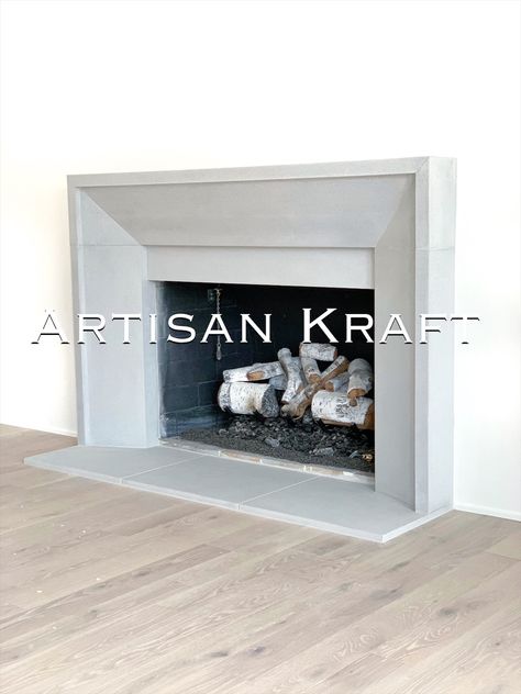 Modern beveled fireplace surround made from cast stone that is meant to resemble real limestone. Hardwood flooring with a hearth and cast mantel surround. Contemporary Fireplace Surround, Picture Frame Fireplace Surround, Beveled Fireplace Surround, Plaster Fireplace Surround, Raised Fireplace, Modern Fireplace Mantels, Limestone Fireplace Surround, Cast Stone Fireplace, Stone Fireplace Mantel