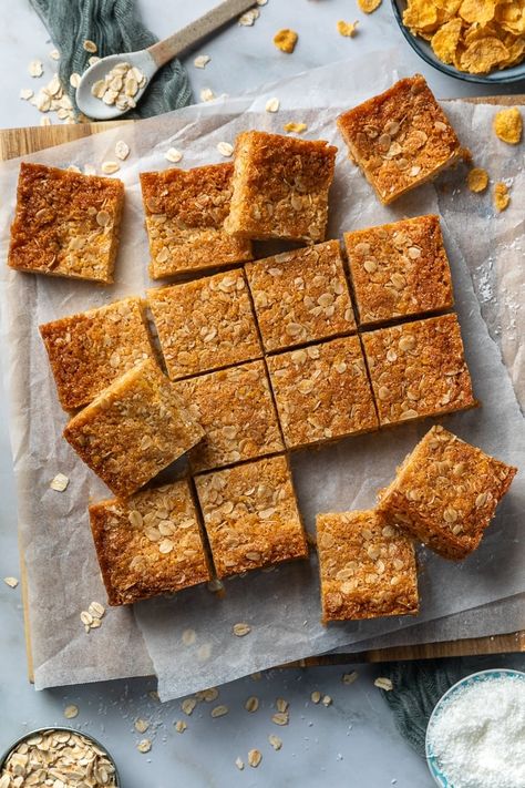 Deliciously chewy Cornflake slice, made from scratch. These golden, buttery squares are made with Corn Flakes, honey, oats and coconut and are the perfect balance of chewy and crispy – perfect for parties and lunchboxes! Cornflake Slice, Cornflake Cake, Mars Bar Slice, Honey Oats, Primary Ideas, Honey Oatmeal, Corn Flakes, Christmas Food Desserts, Easy Cocktails