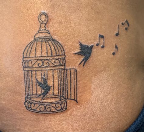 Dark skin tattoo bird cage with bird following the music being set free Jailbird Tattoo, Cage Bird Tattoo, Uncaged Bird Tattoo, Freedom Tattoo For Women Inspiration, Bird And Cage Tattoo, Bird Bath Tattoo, Cages Or Wings Tattoo, Free Bird Tattoos For Women, Bird Cage Tattoos