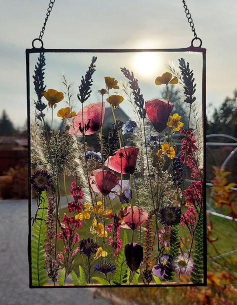 The flower stained glass are made by me in my home. I collect all the flowers and greenery, dry them, iron them and frame them. Every stained glass is unique because flowers in nature are different and are never the same. I use plants that will retain their color for a long time. You must know that they may change color after some time, this is because I don't dye them. EXECUTION: I place flowers between two transparent glass panels. They are connected with copper foil and soldered with tin. Fra Pressed Flower Suncatcher, Pressed Botanical Art, Stained Glass Frames, Flower Suncatcher, Botanical Home, Pressed Botanicals, Pressed Flower Crafts, Bouquet Preservation, Large Decor