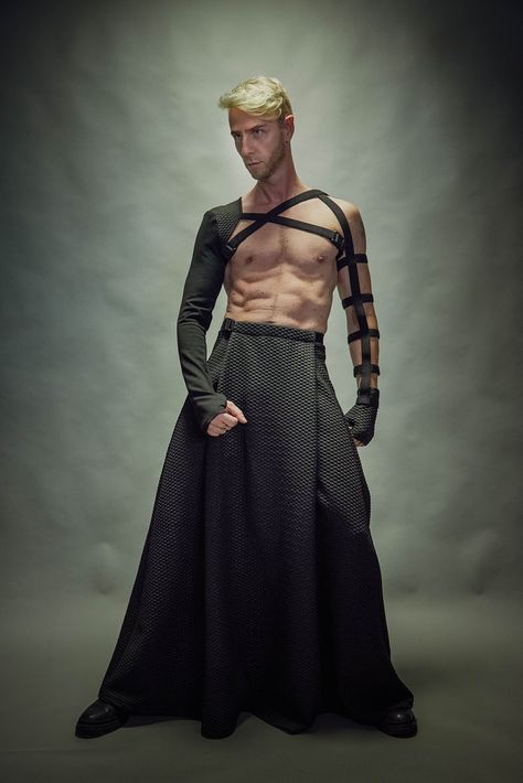 "Black men's maxi skirt with hidden pockets. It is made of a polyester jersey. The skirt has some stretch so it's comfortable for daily wear. The garment is sewn with Eloflex thread which minimizes the risk of seam breakdown on stretch fabrics. The skirt's belt fastens with a Fidlock magnetic buckle. Both, the inner belt and belt with the buckle are adjustable. The garment is easy to care for - cold machine wash, no tumble dry.  Key Features: - Adjustable waist. - Hidden pocket. - Made with spec Male Extravagant Fashion, Men's Skirts Fashion, Gender Bending Fashion Men, Flamboyant Poses Male, Villain Fashion Men, Fae Fashion Male, Weird Mens Fashion, Men In Dresses Art, Men’s Haute Couture