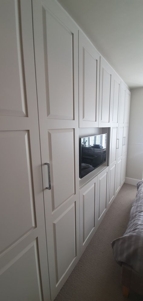 White spray paint finished fitted wardrobes with TV Fitted Wardrobes With Tv, Bespoke Wardrobes, Wardrobe Tv, Fitted Wardrobe, Bespoke Wardrobe, White Spray Paint, Fitted Wardrobes, Unique Storage, Design Maker