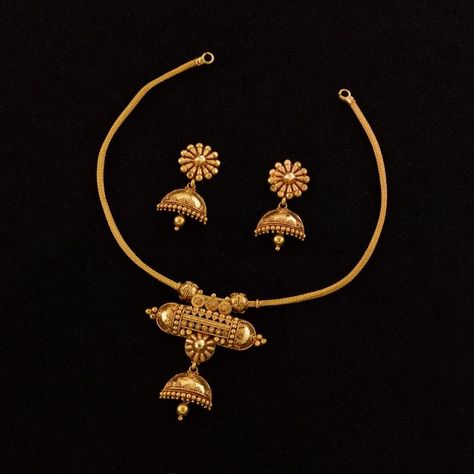 Jukti Maduli Necklace: This dainty 22K handmade gold necklace comprises a simple heley chain on which is suspended the amulet-style centrepiece from which emerges a complete half-jhumka with pasha. This fusion of a very vernacular talismanic symbol to a formal ear ornament is in itself almost revolutionary, juxtaposing the opposing worlds of mystic magic and stately culture in a grand mixture of regional styles of jewel-craft - a small bomb of an ornament that's guaranteed to attract attention. Gold Necklace Set Design, Pure Gold Necklace, Set Design Ideas, Fashion Jewelry Necklaces Gold, Handmade Gold Necklace, Gold Jewels Design, Antique Necklaces Design, Antique Gold Jewelry Indian, Fancy Jewelry Necklace