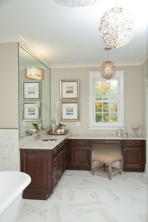 The globe-like light fixtures in this master bathroom are a show-stopper. The intricate scroll work fits perfectly in this elegant bathroom design. L Shaped Bathroom Vanity, L Shaped Vanity, L Shaped Bathroom, Beautiful Bathroom Vanity, Vanity Inspiration, Elegant Bathroom Design, Room Vanity, Timeless Bathroom, Brown Bathroom