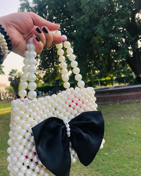 Step up your accessory game with this exquisite white handmade beaded bag, beautifully adorned with a sophisticated black bow. Perfectly blending elegance and artistry, this piece is sure to turn heads and elevate any outfit. Make a statement that’s uniquely you! #HandmadeElegance #BeadedBeauty #fashionstatement #beads #beadwork #fashion #fashionblogger #komalkreate #bag #baglover #bagfashion #bagforwomen #luxurylifestyle #instagood #instagram #instafashion #pakistan Pearls Bag, Beads Bag, Bead Bag, Bag Designs, Pearl Bag, Ladies Purse, Beaded Bag, Beaded Handbag, Beaded Accessories