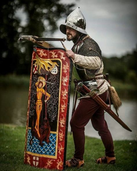 Man with crossbow and pavise. A pavise is a convex shield used during the late 14th to early 16th centuries. Often large enough to cover the entire body, it was utilized by archers and infantry soldiers. The name is thought to come from the city of Pavia, Italy. Pavise Crossbowmen, Pavise Shield, Pavia Italy, Medieval Crossbow, 15th Century Armor, Century Armor, Medieval Ages, Historical Armor, Wars Of The Roses